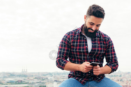 在手机上打短信的胡须男子拉丁互联网男性水平幸福阅读微笑社会技术短信复制空间高清图片素材