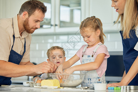学做合格党员有爱心的白人父母和他们的小女儿在家里的厨房里一起烘烤 妈妈和爸爸在凌乱的厨房里教女儿们如何做面团 学烘焙的姐妹们背景