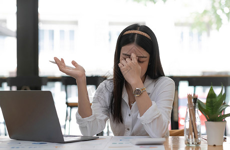 遭受了千年压力的亚洲女商务人士或办公室雇员感到受苦受难 对工作表现不满意 患有抑郁综合症分析师高清图片素材