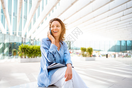 漂亮的caucasian女性商务人士在电话交谈时微笑着笑容 她很聪明的 有吸引力的黑发女商务人士与客户谈手机项目联系人商务商业企背景图片