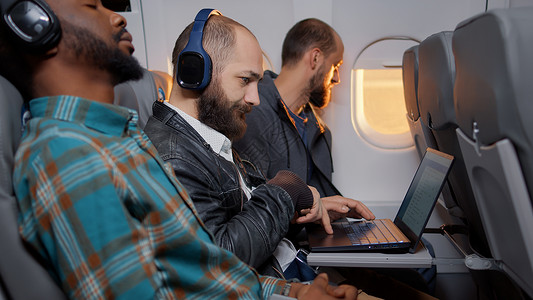人飞行乘机使用膝上型计算机的商务乘客背景