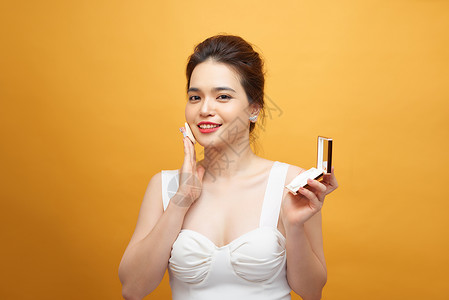漂亮的亚洲女孩在粉扑上照镜子时 一边喷粉底粉一边化妆或化妆女性女士魅力镜子软垫化妆品皮肤背景图片