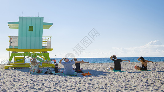 一群人在日出时 在迈阿密佛罗里达南部海滩的海滩上做瑜伽海岸线天线闲暇旅游救生员建筑城市冥想女士建筑学热带高清图片素材