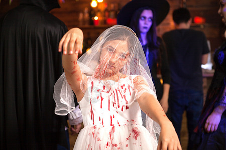 婚纱有血素材小女孩的肖像打扮成一个新娘 在圣殿派对上沾满鲜血背景
