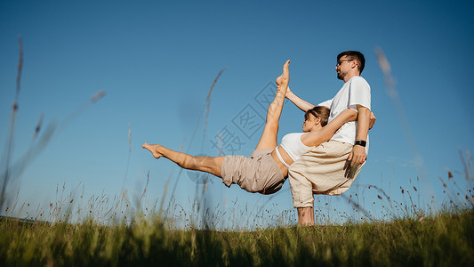 yoga在野外练瑜伽时穿着像做难拍的长相 背景是蓝天 在野外练习Yaga Yoga门外男性夫妻女士日落闲暇福利专注女性成人活力背景