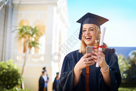 毕业帽学生一位快乐的年轻女子在毕业日站在外面 我对这个里程碑感到非常喜悦背景