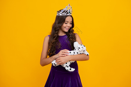 女孩公主梦戴着金色王冠的小女王 十几岁的女孩公主拿着皇冠头饰 舞会 童年的概念 快乐的女孩脸 积极和微笑的情绪背景