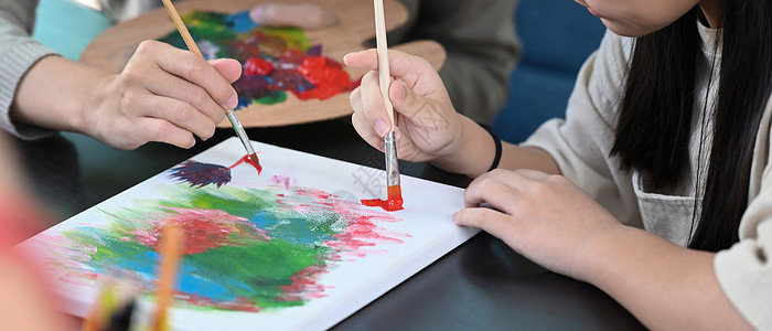 在艺术课上 和老师一起剪裁的小女孩画像画家高清图片素材
