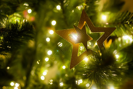 发光星星装饰圣诞树装饰着星星 球和玩具 墙壁背景 新年横幅概念金子星形装饰品火花卡片圣诞假期魔法展示房间背景