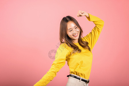 亚洲青年女子以鼓舞人心的面容表情和举起手来跳舞工作室派对闲暇快乐手势行动女士学生喜悦舞蹈家背景图片