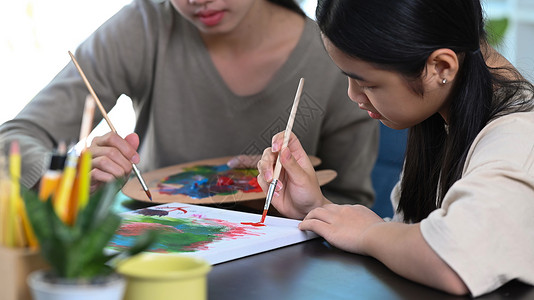 年轻女教师帮助小女孩在艺术课上画画 (笑声)艺术品高清图片素材