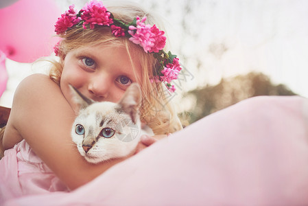 可爱胖胖猫气球童年的幸福 一个快乐的小姑娘抱着一只小猫 看着外面自然界的摄像头花园粉色裙子气球金发女郎动物乐趣女性花朵孩子们背景
