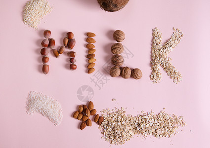 美食促销展架粉红色背景的平面字母牛奶 使用健康成份 谷物 坚果和种子来复制广告空间背景