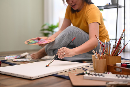休闲的年轻女性在画布上用水彩画艺术画 在家里享受创意活动 艺术 爱好和休闲活动概念松弛高清图片素材