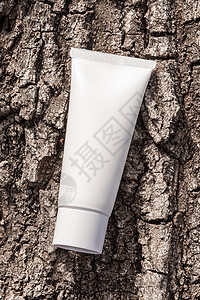 目录树美容产品包装模型;树皮天然背景上的管状有机化妆奶油;用于皮肤护理常规的催泪瓶 润滑剂 洗发水背景