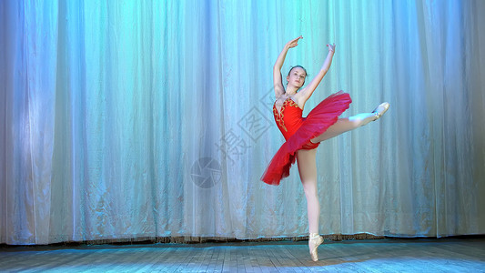 年轻芭蕾舞者穿红色芭蕾舞裙和指尖鞋 跳优雅的芭蕾运动 巡回童话表演及节奏短剧背景图片