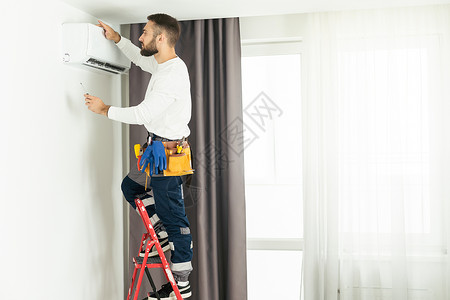 在室内修理空调机的男技艺员维修温度修理工技术房间男性技术员状况男人护发素服务高清图片素材