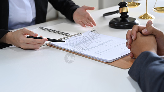 核糖核酸律师在合同文件上显示签名位置并向其客户提供法律咨询和法律建议的裁剪照片背景