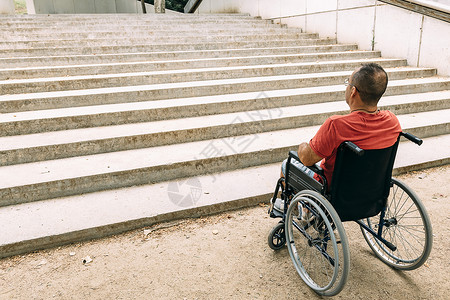 男子在轮椅上因楼梯而停下来生病的高清图片素材