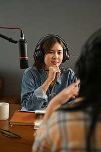 在广播家庭工作室录制播客时 积极的女电台主持人聆听与客人的有趣对话电脑博客记录嗓音耳机说话桌子企业家媒体面试技术高清图片素材