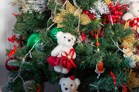 树上的熊圣诞树上挂着一只熊形状的漂亮圣诞装饰品 圣诞节的家居装饰 新年室内的软玩具松树礼物市场金子饰品毛绒庆典假期房间旗帜背景