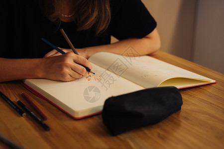 一个女孩坐在咖啡店里 画着彩色铅笔的素描本草图艺术咖啡馆素描插图天赋面包笔记本女士教育背景图片