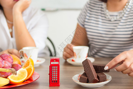 巧克力王国传统下午的英国仪式 下午茶茶 象征着像玩具电话箱这样的不纯度女士女性英语文化摊位盒子巧克力水果甜点电话亭背景