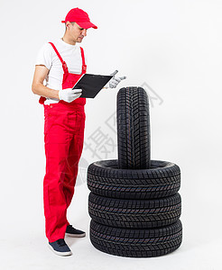 在修理厂拿着轮胎的技工 更换冬季和夏季轮胎作坊车轮快乐店铺引擎盖男性职业工作服维修机械男人高清图片素材