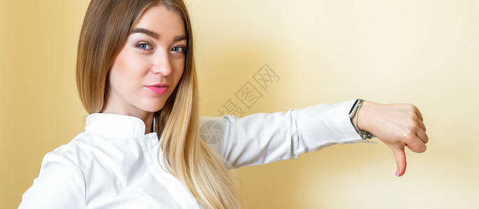 年轻漂亮的女商务人士穿着白衬衫 拇指从黄色背景上被孤立下来 Yeal Black工作室经理横幅女孩分歧手指展示衬衫失败手势概念高清图片素材