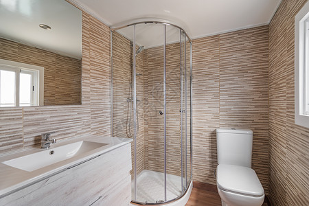 浴室简便 有淋浴房 白马桶 木家具和米砖 装修后的公寓内部背景图片