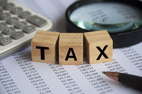 税收宣传带放大镜 计算器和数字分析背景的木块税字 税务概念背景