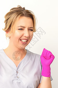 穿着粉红色手套的caucasian女医生快乐地庆祝白种背景并举起拳头工人粉色女孩喜悦万岁惊呼成就情绪女士胜利垂直的高清图片素材