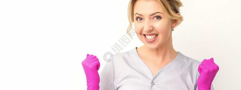 穿着粉红色手套的caucasian女医生快乐地庆祝白种背景并举起拳头运气微笑享受动机成就成功女士优胜者庆典惊呼快乐的高清图片素材