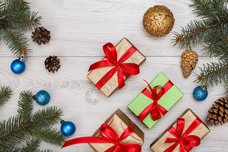 礼品盒 带锥子的鲜树枝和板上的圣诞玩具作品礼物问候语丝带甘蔗传统木头雪花季节松树背景图片