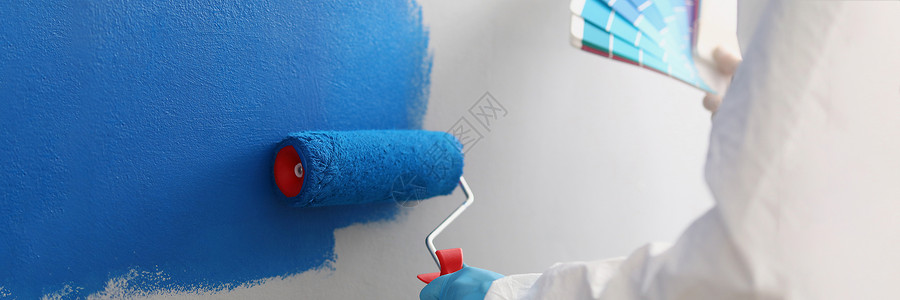 现场工人 涂画用蓝彩油漆墙覆盖的刷刷工具背景图片