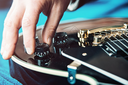 男性用手改变电吉他设置 调制一个小调制器创造力演员广播工作室风俗抗震流行音乐创新收音机服务背景图片