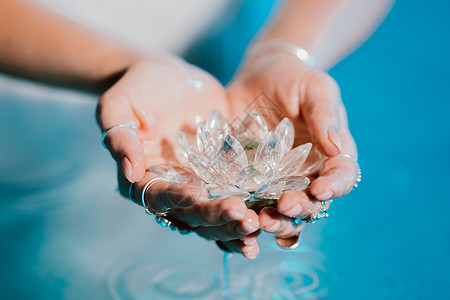 水晶花拿着易碎的莲花的妇女 清澈的水珠从水晶中滴落 宗教 昆达里尼 冥想 脉轮 精神内心世界的概念抛光女士叶子椭圆形矿物玻璃女性美丽手背景