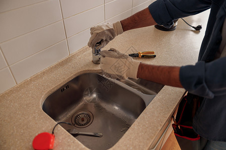 在厨房特写男性水管工修理水槽水龙头 优质的水暖公司服务男人安装承包商管道扳手维修职业工人修理工浴室英俊的高清图片素材