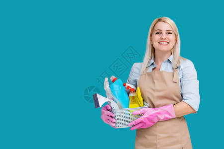 白人漂亮女佣戴着橡胶手套保护双手的照片 拿着桶 蓝色背景上隔着清洁用品洗涤剂高清图片素材