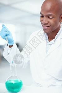 适量的化学品 一位有吸引力的男性科学家在实验室中将一种化学物质添加到另一种化学物质中背景图片
