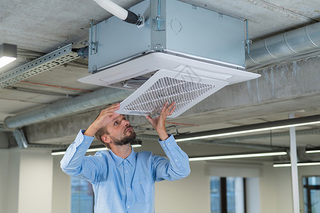 白胡子男正在修理办公室的空调机 他叫工作空调修理工通风检查温度护发素气候电工压缩机使固定高清图片素材