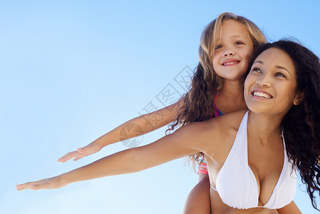 一位年轻母亲带着女儿回海滩上 他们都伸出双臂来抱她的女儿 (掌声)看着高清图片素材