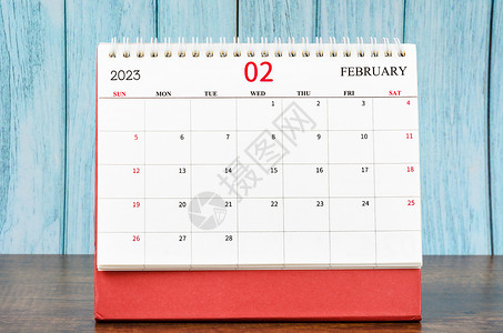 2023年2月组织者月度案头日历 用于在木制桌上规划2023年背景图片