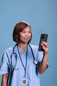 在网上视频通话中 护士带着智能手机与远程医生交谈的热情好听的护士背景图片