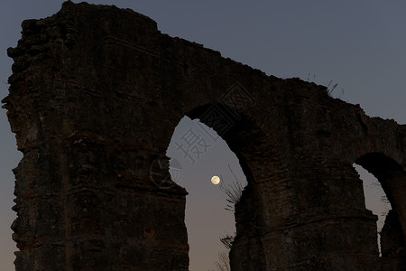 石月亮背面有满月的石形拱门全景隧道月亮宗教月光考古学辉光水平月球阴影背景