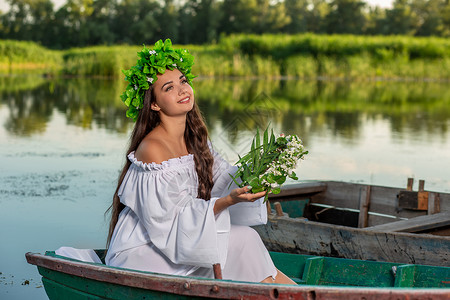 深色头发长发的女神 穿着白色古董礼服 坐在河中央的一条船上花朵魔法若虫神话魅力童话美人鱼成人裙子女孩优质的高清图片素材
