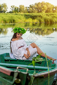 深色头发长发的女神 穿着白色古董礼服 坐在河中央的一条船上花朵魅力裙子成人魔法女孩美人鱼冒充神话若虫白种人高清图片素材