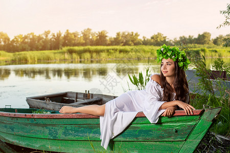 深色头发长发的女神 穿着白色古董礼服 坐在河中央的一条船上女孩童话神话海滩美人鱼若虫冒充花朵裙子魅力丰富多彩的高清图片素材