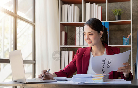 微笑的年轻女性在办公室和平板电脑上看工作商业文件经理高清图片素材