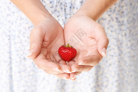 我留了最后一个草莓给你 给一个手拿着草莓的女人刻的图像图片